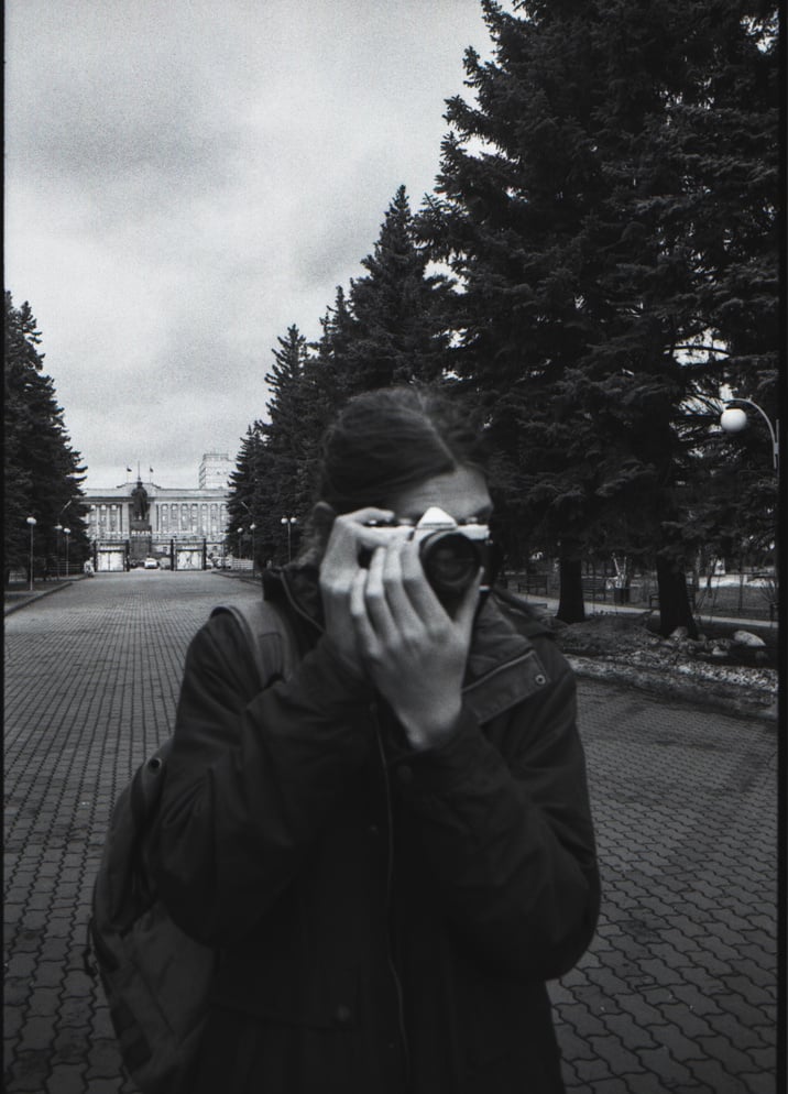 A Person in Black Jacket Taking Photo with a Camera